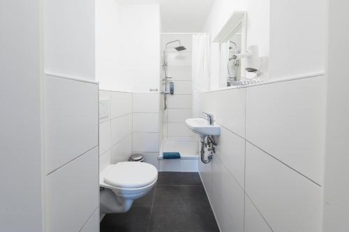 杜塞尔多夫贝罗里纳豪斯宾馆的白色的浴室设有卫生间和水槽。