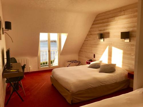 Saint-Guénolé国际之家斯特伦酒店的酒店客房设有两张床和窗户。