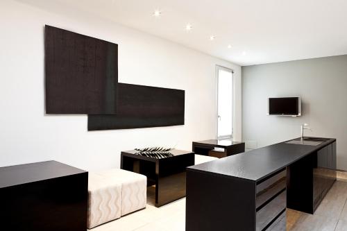 博洛尼亚穆亚酒店的客厅配有黑色家具和电视