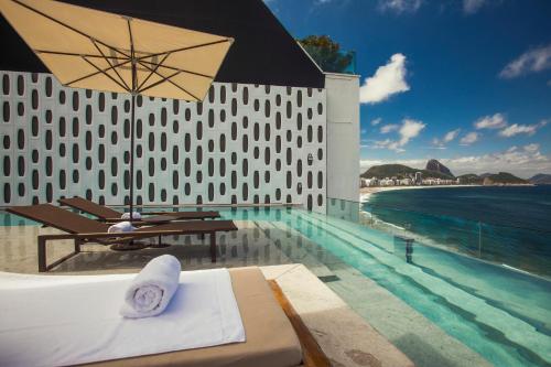 里约热内卢埃米利亚诺里奥酒店的一个带桌子和遮阳伞的游泳池