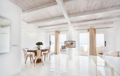易莫洛林Rocabella Santorini Hotel & Spa的白色的客厅配有桌椅