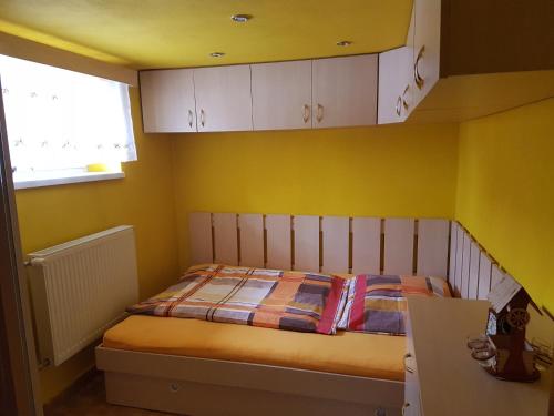 利普托斯基米库拉斯Apartment Alta的一间卧室设有一张黄色墙壁和窗户的床