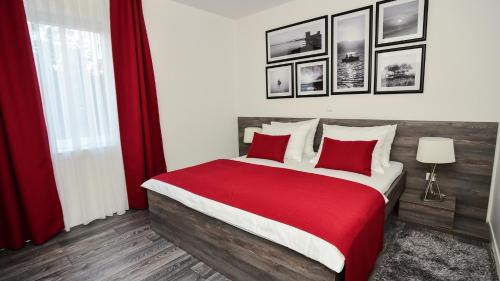 维尔Sunset Deluxe Apartments的卧室配有一张大床,提供红色床单和枕头