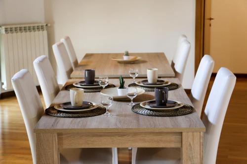 贝加莫多尼采蒂皇家住宿加早餐旅馆的一张带白色椅子的木桌和木制用餐室