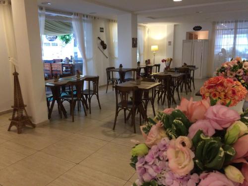 累西腓Scenarium Hotel的一间带桌椅和鲜花的用餐室