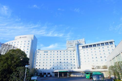 成田成田东武机场酒店的一座白色的大建筑,前面设有停车场