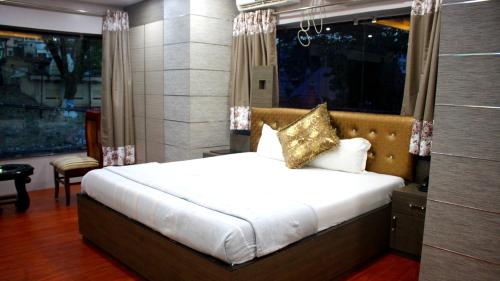 古瓦哈提Hotel Shreemoyee Inn - Kamakhya Temple的一间卧室设有一张床和一个大窗户