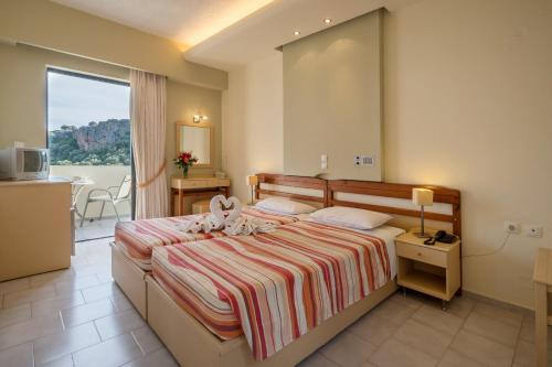 罗达奇诺Polyrizos Hotel的酒店客房设有一张床和一个阳台。