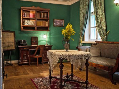 比亚沃维耶扎卡斯齐公寓的客厅设有绿色墙壁和鲜花桌