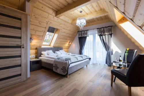 考斯赛力克Giewont Residence的一间带一张床的卧室,位于带木制天花板的房间内