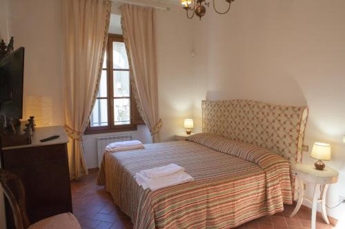 斯卡尔佩里亚Villa Torricelli Scarperia - Il Giardinetto Residence的一间卧室设有一张床、一台电视和一个窗口。