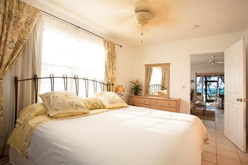 NCAHollywood Beach Suites Turks and Caicos的卧室配有一张大白色床和窗户