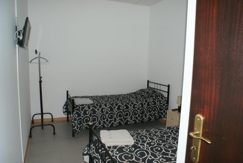 古勒冈Quartos do Lagar的一间卧室配有两张黑白床单