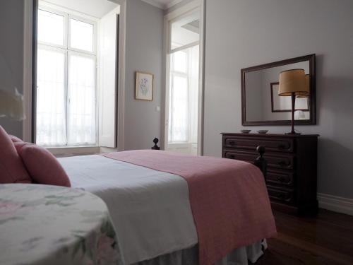 蓬塔德尔加达Porta26的一间卧室配有一张床、梳妆台和镜子