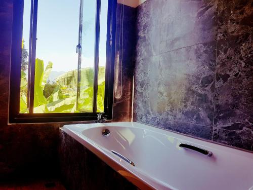 拜县拜县常山度假村的带窗户的浴室内的白色浴缸