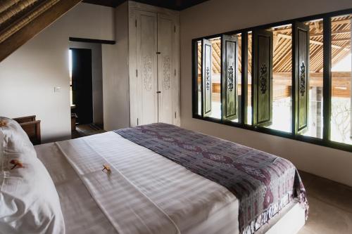 佩母德兰Jeda Villa Modern Stylish Luxury Villa的一间卧室设有一张大床和两个窗户。
