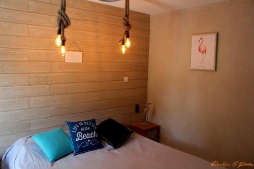 拉格朗德默特Le flamant - Appartement P2 de 40m2 grande terrasse-parking-wifi的一间卧室配有一张带蓝色枕头和灯光的床。