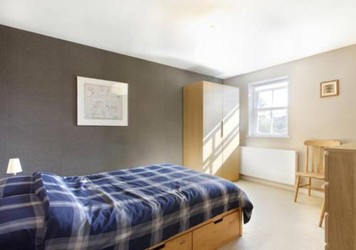 瓦灵福德D&E Homestay的一间卧室配有一张带蓝色铺面毯子的床