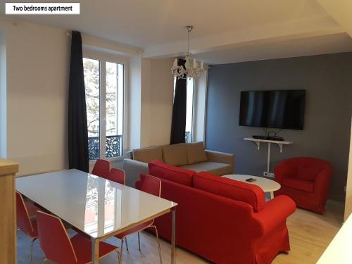 万塞讷万塞讷公寓的客厅配有红色的沙发和桌子