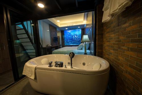 曼谷V20 Boutique Jacuzzi Hotel - SHA Extra Plus的卧室内的浴缸