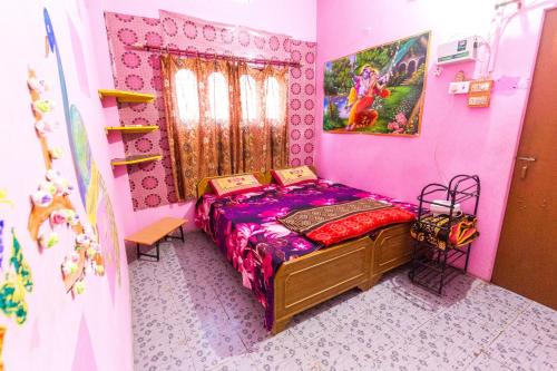 瓦拉纳西索密特佩英宾馆的粉红色客房内的一间卧室,配有一张床