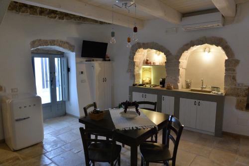 阿尔贝罗贝洛Trullo Assenzio的厨房以及带桌椅的用餐室。