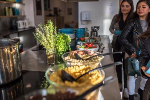 布达佩斯艾沃宁旅馆的两名妇女站在厨房里,厨房里摆放着餐桌和食物