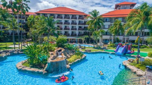 哥打京那巴鲁The Magellan Sutera Resort的一个带瀑布和水滑梯的度假游泳池