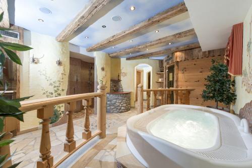 格罗萨尔索恩霍夫酒店的一间大浴室,位于房间中间,配有浴缸
