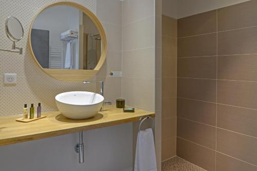 Aureville恩马基酒店的一间带水槽和镜子的浴室