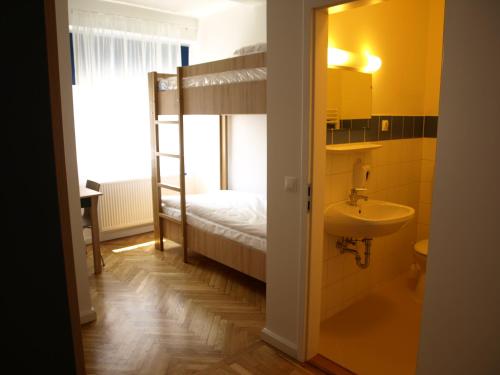 佩奇Ciszterci Szállás Pécs的一间带水槽和一张双层床的浴室