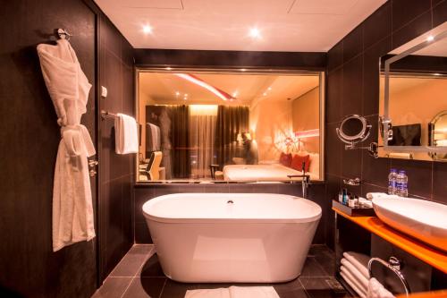 马斯喀特卡内连荣耀鲍尔酒店的一间带浴缸和大镜子的浴室