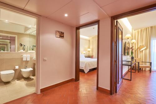 波尔蒂芒佩尼娜高尔夫度假酒店的一间带卫生间的浴室和一间带一张床的卧室