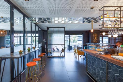 拉科鲁尼亚拉科鲁尼亚宜必思尚品酒店的餐厅设有供应橙色凳子的酒吧