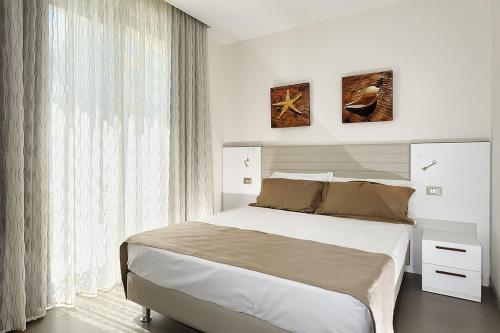里米尼卡瓦露西奥圣马力诺住宅酒店的一间卧室设有一张大床和一个大窗户
