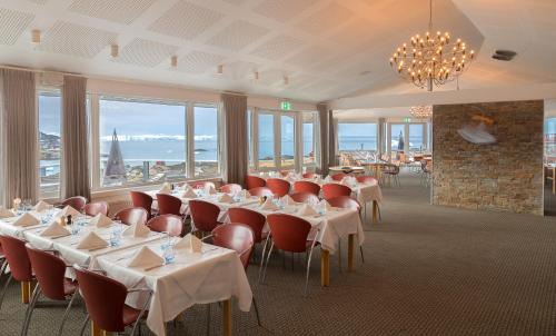 伊卢利萨特北极酒店的用餐室设有桌椅和窗户。