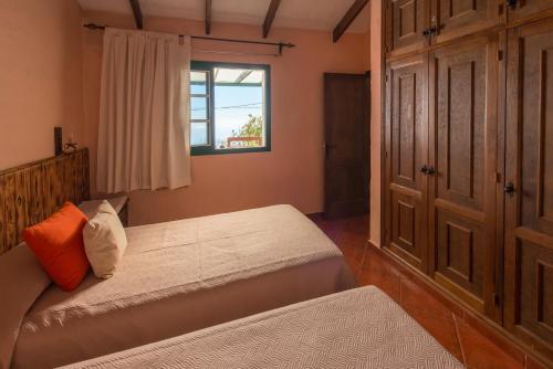 IsoraCasa Abuelo Buenaventura的一间卧室设有两张床和窗户。