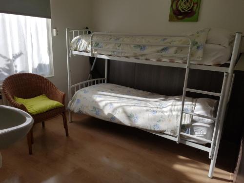 阿赫特克克vakantiewoning zeumeruus的一间卧室配有两张双层床和椅子