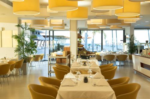 卡尔帕索斯阿丽蒙德马蕾酒店的餐厅设有桌椅和大型天花板。