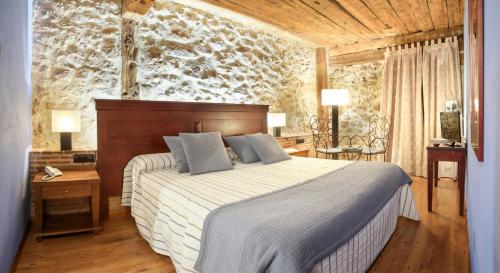 乌塞罗波萨达罗斯腾普拉里奥斯酒店的一间卧室设有一张床和石墙