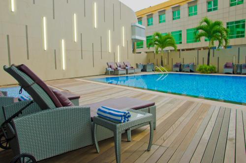 名古屋那格亚希尔巴达姆酒店的一个带椅子的游泳池和一间酒店