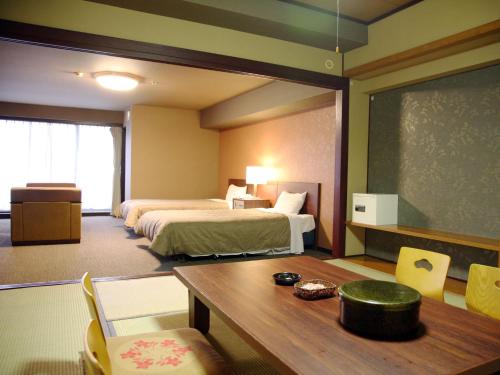 雾岛市雾岛城堡饭店的酒店客房设有两张床、一张桌子和一个黑板