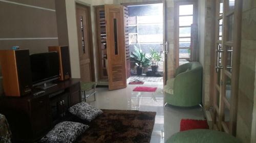 玛琅斯亚里亚格拉哈迪民宿的客厅配有电视和绿椅