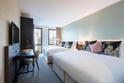阿姆斯特丹阿姆斯特丹莫奈花园酒店 的酒店客房设有两张床和电视。