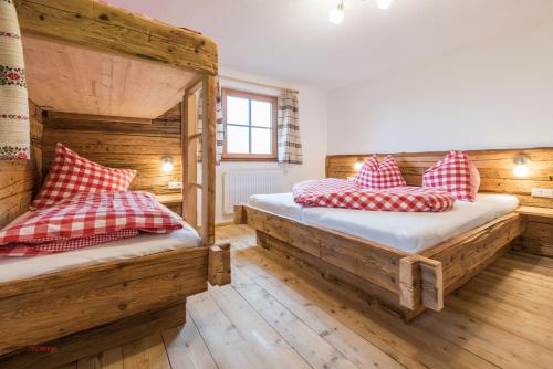皮森多夫Almliesl PIES-533的配有木墙和木地板的客房中的两张床