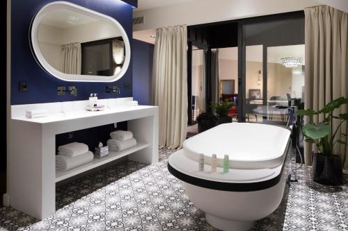 波尔多波尔多中心卡丁诺酒店的带浴缸、卫生间和镜子的浴室