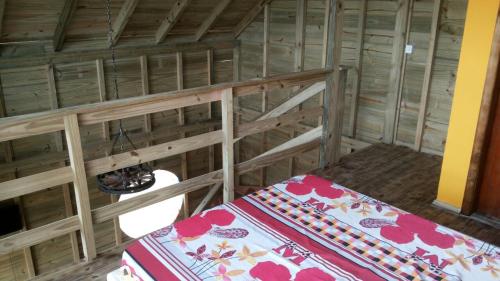 帕罗卡Cabana Rústica Praia do Sonho的木制客房内的一间卧室,配有一张床