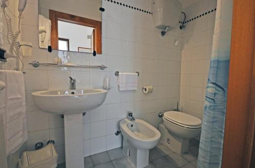 多诺然蒂克Locanda Menabuoi的白色的浴室设有水槽和卫生间。