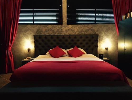Kortessem薇拉鲁克斯酒店的一间卧室配有一张带红色枕头的大床