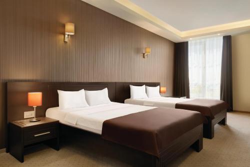 康斯坦察Ramada by Wyndham Constanta的酒店客房设有两张床和窗户。